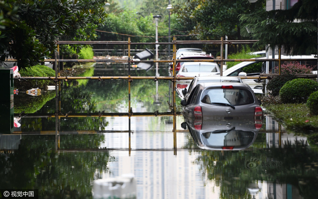 武汉小区积水9天未退 工人搭栈桥供居民出入