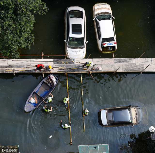 武汉小区积水9天未退 工人搭栈桥供居民出入