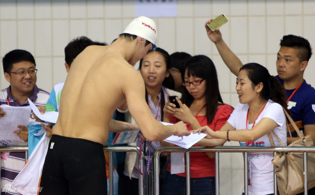 孙杨(前)赛后为志愿者签名