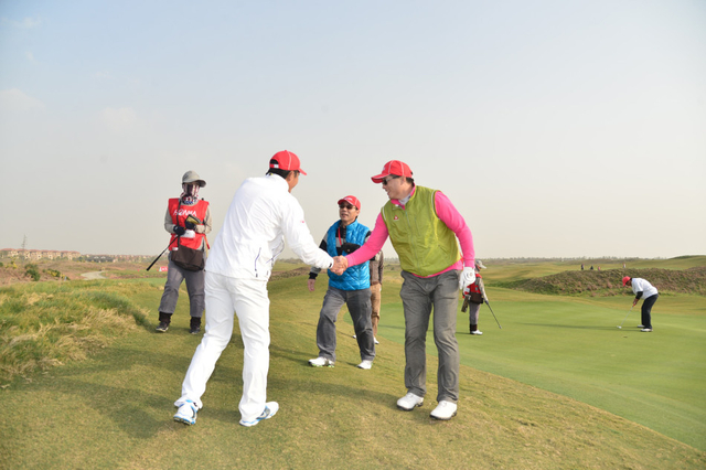 梁文冲与球友握手交谈