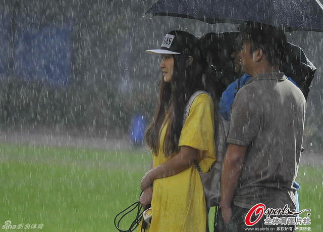 记者及球迷冒雨观看