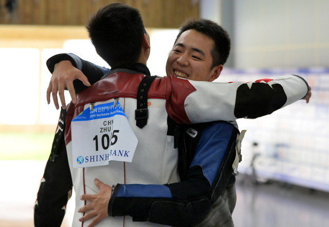 曹逸飞(右)夺冠后和队友朱启南拥抱