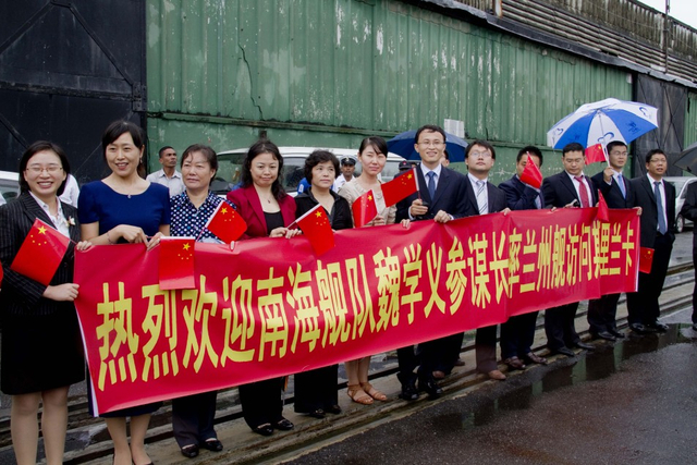 当地华侨华人手持标语欢迎