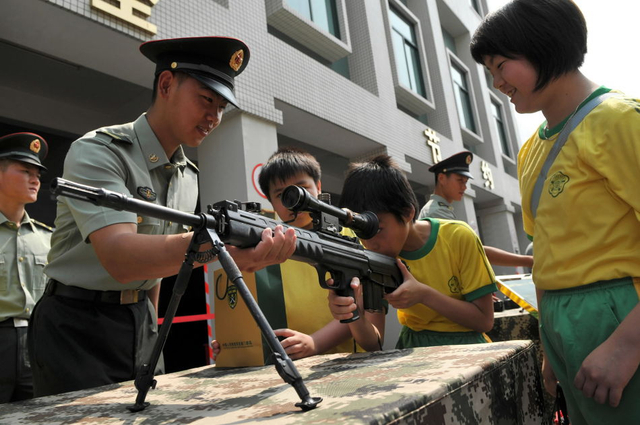 一名澳门小学生在用展示的枪械瞄准