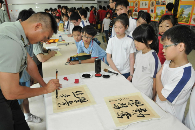 一名驻澳门部队士兵为小学生即席挥毫