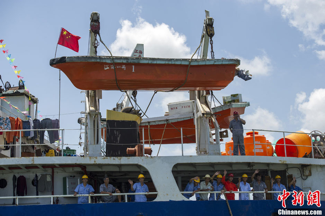 远赴南沙作业的渔民向岸上送行的民众挥手