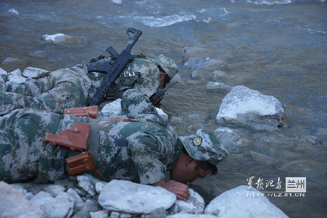 执勤官兵路过小溪开心地喝水