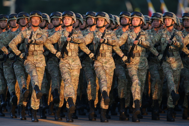 身着新式多地形迷彩作战服的方队正在演练