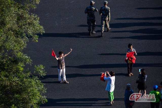 手持国旗的民众在现场留影