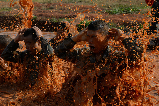 参训官兵共同完成穿越水坑训练
