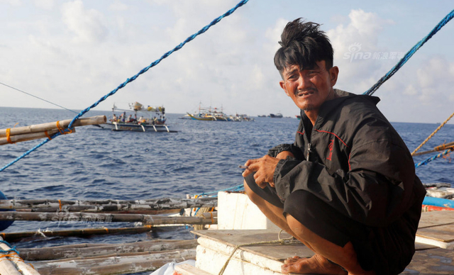 中国海警船正巡弋黄岩岛:旁边菲律宾渔民捞鱼