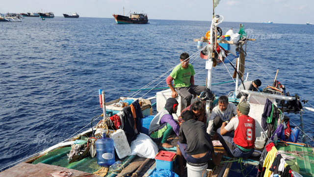 中国海警船正巡弋黄岩岛:旁边菲律宾渔民捞鱼