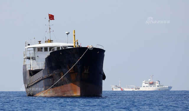 中国海警船正巡弋黄岩岛:旁边菲律宾渔民捞鱼