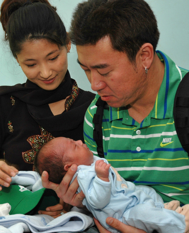 金女士夫妇看着代孕产出的孩子